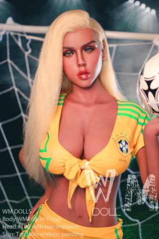 Flora – 168cm F cup wearing a yellow Brazil soccer jersey, posing with a soccer ball in a sports setting.