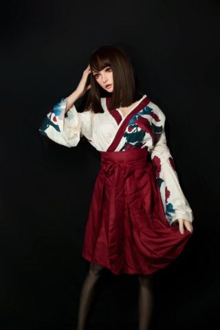 Kanon – 165cm Elsa Babe silicone sex doll wearing a floral-patterned kimono with a red sash, posing against a dark background.
