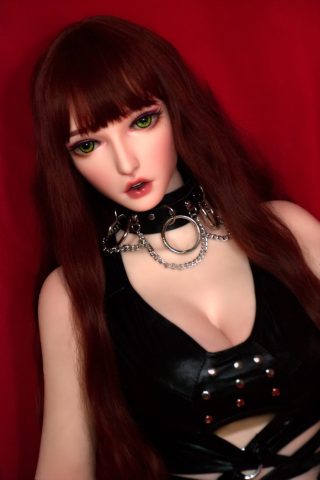 Yuuki – 165cm Elsa Babe silicone sex doll with long brown hair, wearing a black leather outfit and silver accessories against a red background.