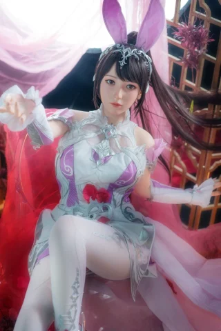 Zari 155cm C Cup fair skin doll in a detailed white and pink outfit with bunny ears, sitting gracefully.