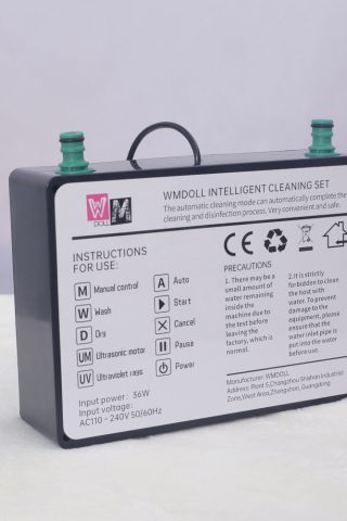 WM Doll Intelligent Cleaning Set. The device features a rectangular black body with green connectors on top and instructions printed on the side.