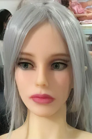 Doll with silver hair and green eyes, featuring a neutral expression and soft pink lips.