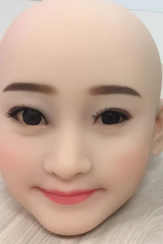 150cm doll head with smooth skin, large dark eyes, subtle makeup, and a neutral expression on a light wooden surface.