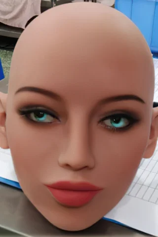 Head model with pointed ears, featuring blue eyes, defined lips, and a smooth skin texture, placed on a table.