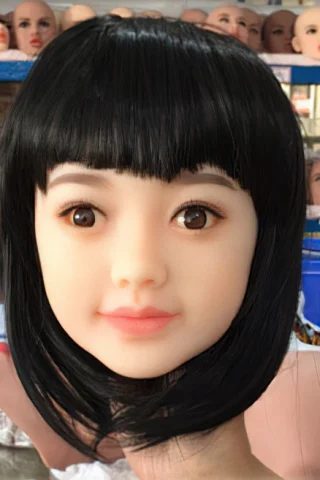 171 doll head with black hair, featuring brown eyes and a neutral expression, set against a background of mannequin heads.