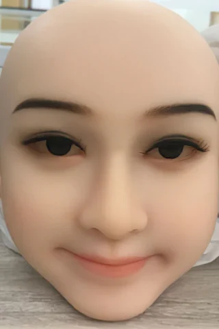 Bald doll head with realistic facial features, including closed eyes, subtle smile, and natural skin tone.