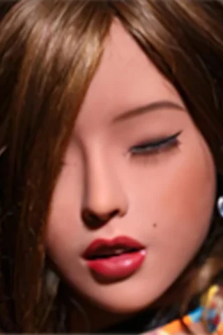 Doll 223 with long brown hair and closed eyes, wearing a colorful patterned shirt and blue earrings.