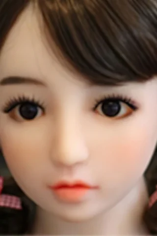 Doll 225 features a detailed face with large eyes, soft lips, and styled dark hair adorned with pink ribbon earrings.