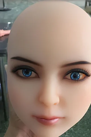 Doll head with blue and brown eyes, smooth skin, and no hair, held against a blurred background.