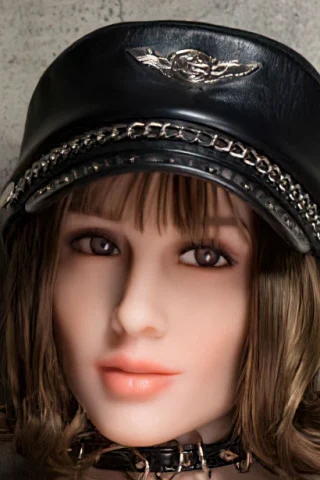 303 doll with short brown hair wearing a black leather cap and choker, set against a textured gray background.