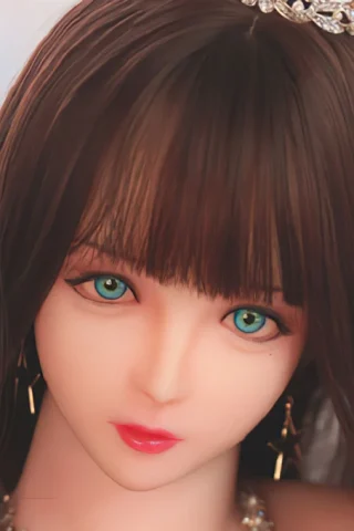 314 doll with long brown hair and green eyes, wearing a tiara and earrings, featuring a neutral expression.