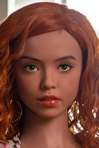 Doll 319 with curly red hair and brown eyes, wearing a floral top, set against a bright window backdrop.