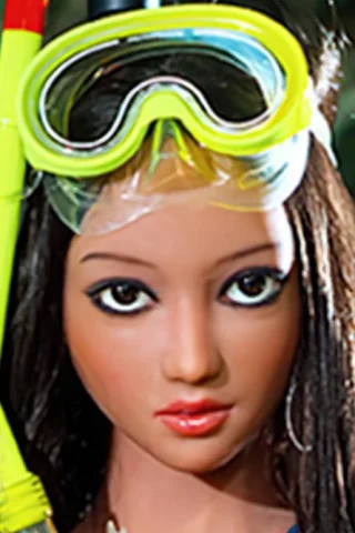 Snorkeling doll with long dark hair, wearing yellow snorkel gear and a blue swimsuit, set against a natural background.