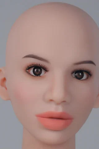 Doll head with realistic features, bald scalp, brown eyes, and soft pink lips against a neutral background.