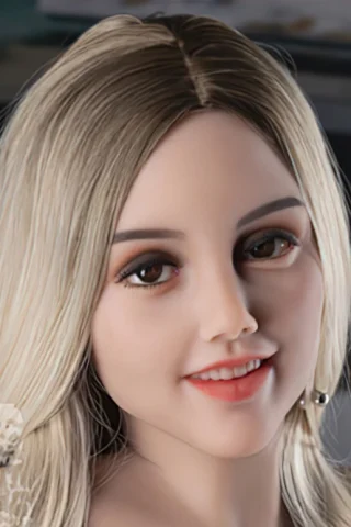 414 doll with long blonde hair, smiling softly, wearing a casual outfit, set against a blurred background.