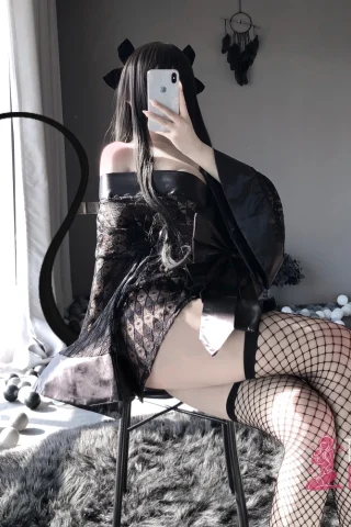Lace Japanese Kimono featuring a black design, worn off the shoulders with fishnet stockings and a playful pose.