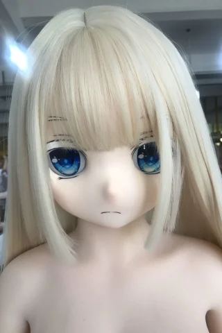 WM/YL/OR Doll head features long blonde hair, blue eyes, and a neutral expression, set against a blurred background.
