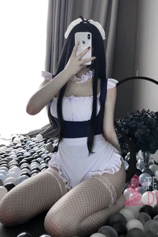 Blue Maid outfit. The figure kneels on a floor covered with gray and white balls, wearing a short blue dress with ruffles and fishnet stockings.