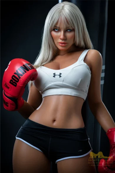 Woman with long blonde hair wearing boxing gloves, white sports bra, and black shorts in a gym setting; Irontech model Hedy S26 164cm sex doll.