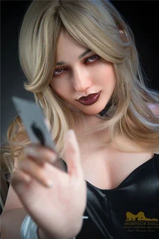 Hazel S18 166cm B Cup Irontech doll with long blonde hair, wearing a black outfit and holding a card.