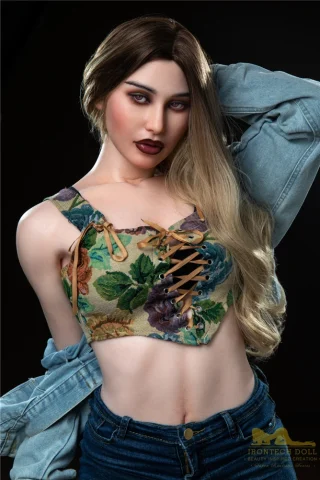 Hazel S18 166cm B Cup Irontech doll wearing a floral crop top and denim jacket, posing with long hair and bold makeup.