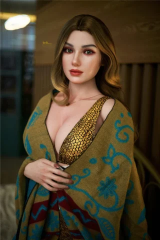 S1 166cm C Cup Irontech doll wrapped in a patterned shawl, wearing a gold dress, with long wavy hair and striking makeup.