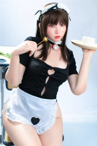 Suki S20 166cm B Cup Irontech wearing a black top and white apron, holding a plate and chopsticks.
