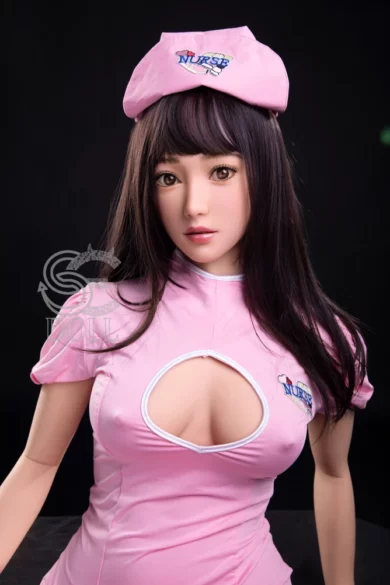 Manami 163cm E Cup #079 SE Doll in pink nurse outfit and hat against dark background