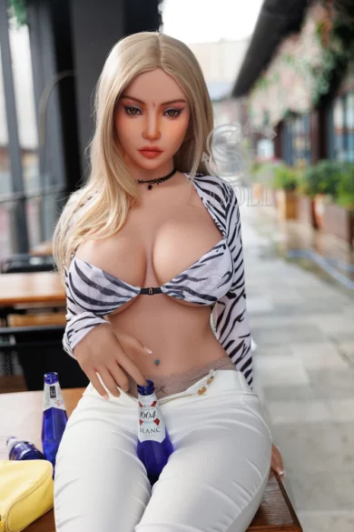 Lifelike Melantha 157cm H Cup SE Doll in zebra-patterned top and white pants sitting at outdoor table with a beer bottle