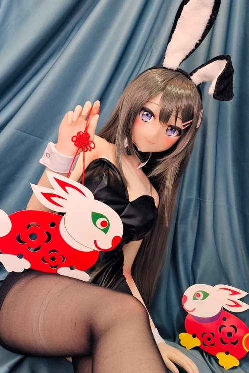 Figure in black costume with bunny ears sits holding a red rabbit decoration near another similar ornament and Usagi 155cm C Cup love doll with #88 head.