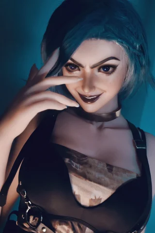 Kinsley Clark 165cm features short blue hair, a dark harness top, and a playful pose with a smirk.