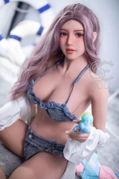 Yasmin 163cm E Cup doll with long purple hair, denim bikini, white shirt, holding blue toy.