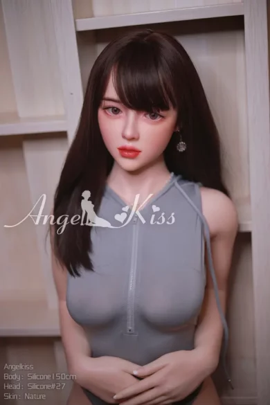 AK150 S27 Silicone Angel Kiss doll with long brown hair and gray sleeveless top against wooden background