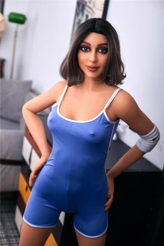 Christel 168cm B Cup doll wearing a blue bodysuit with white trim, standing in a modern indoor setting.