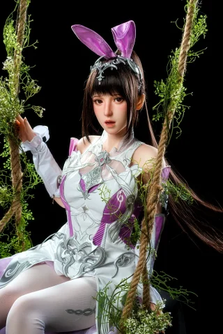 Astra GE108 155cm C Cup Zelex sits on a swing adorned with greenery, wearing a white and purple outfit with bunny ears.