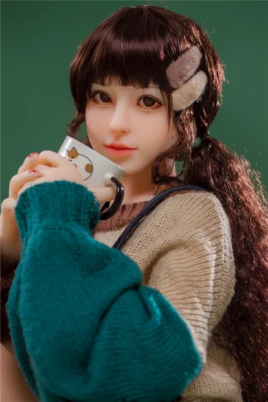 sex doll with long dark hair holds a mug in greenery wearing beige sweater and teal shawl