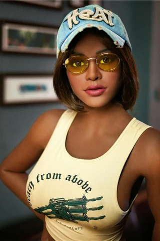 Plus Rachel 164cm E Cup wearing a yellow tank top and blue cap, with sunglasses and a relaxed pose indoors.