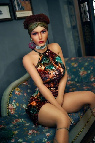 Plus Scarlet 164cm E Cup doll wearing a colorful patterned dress, seated on a floral couch with stylish accessories.