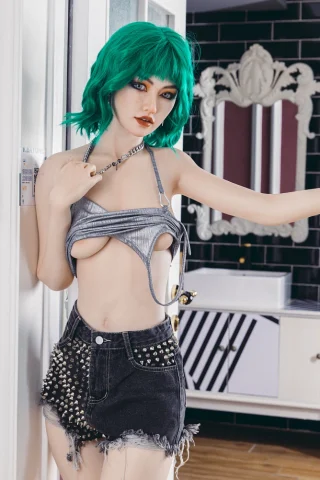 Wushi 174cm C Cup Starpery stands in a bathroom doorway wearing a silver top and studded black shorts.