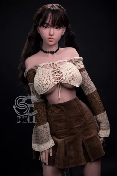 Hitomi 161cm F Cup SE Doll in brown striped sweater and pleated skirt against dark background