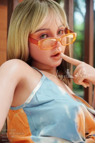 AK15-159cm Tan Silicone Angel Kiss doll wearing a colorful dress, with blonde hair and orange glasses, posing playfully.