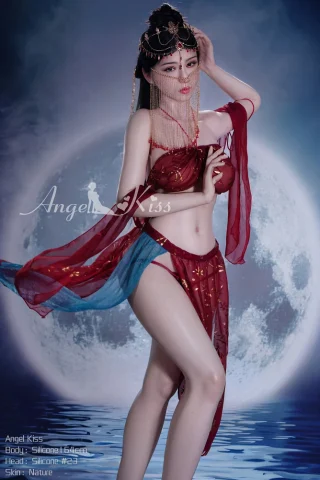Angel Kiss 5ft5 in a red and blue outfit, posing with a moonlit background and intricate jewelry.