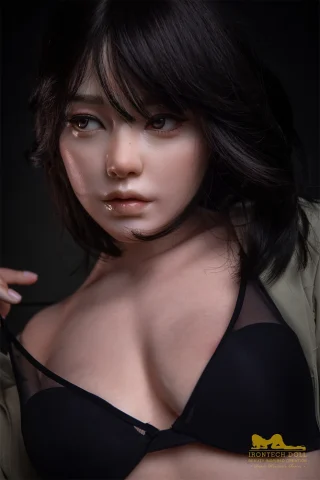 S40 163cm Irontech Doll with short black hair, wearing a black bra and a sheer top, gazing directly at the viewer.