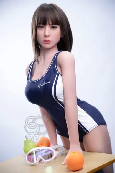 Skyler 153cm F Cup SE Doll in blue swimsuit leans on table with ski goggles and fruit nearby