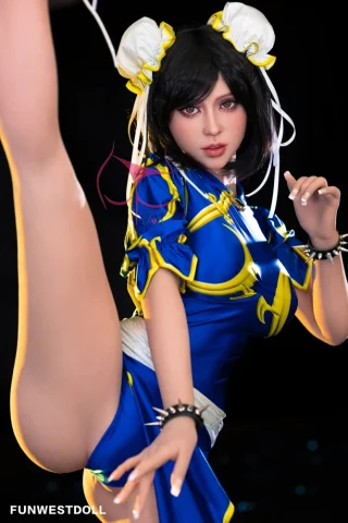 Lucy #032 155cm F Cup Tan poses with one leg raised, wearing a blue and yellow outfit with white ribbons in her hair.