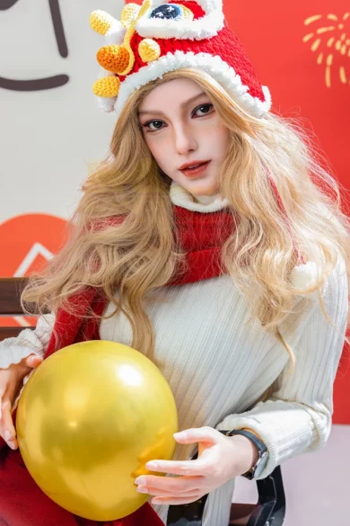 Festive display with red and white hat and scarf on S31 163cm C Cup Irontech figure holding yellow balloon against red backdrop.