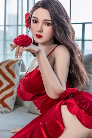 Xue 171cm D Cup Starpery poses in a red satin dress, holding a rose, with long wavy hair and a floral accessory.