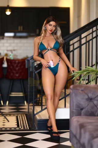 S30 164cm Irontech Dark Tanned doll in a teal bikini, standing on a staircase with a playful expression, holding a toy.