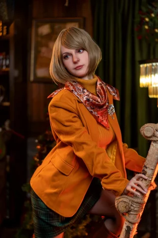 Lady.22 171cm G Cup in an orange blazer and patterned scarf, posing beside a rustic wooden pole in a cozy, decorated setting.