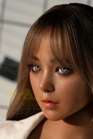 164cm S40 Dark Tanned 2 Irontech silicone doll with long brown hair and blue eyes, wearing a white blazer against a grid background.